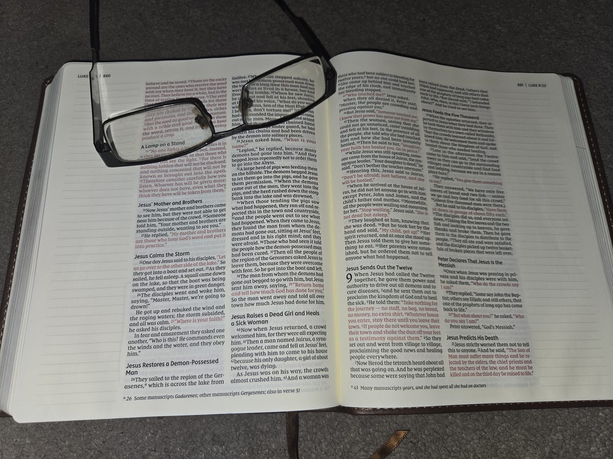 Reading glasses on an open Bible at Luke 8, over the story of the man called Legion