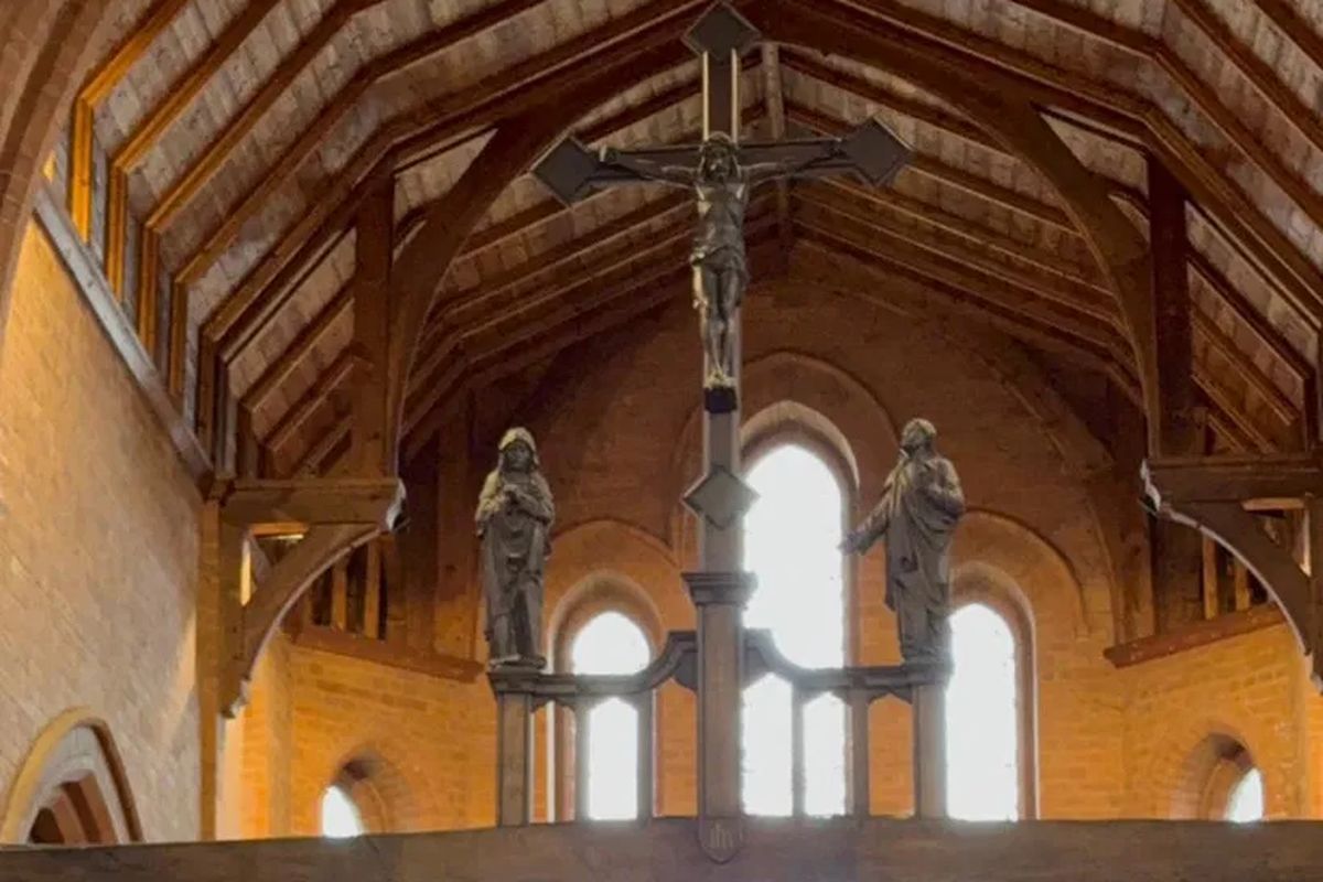 A wooden crucifix high in the roof beams of a church