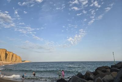 A wide sky over the sea, with cliffs in the distance