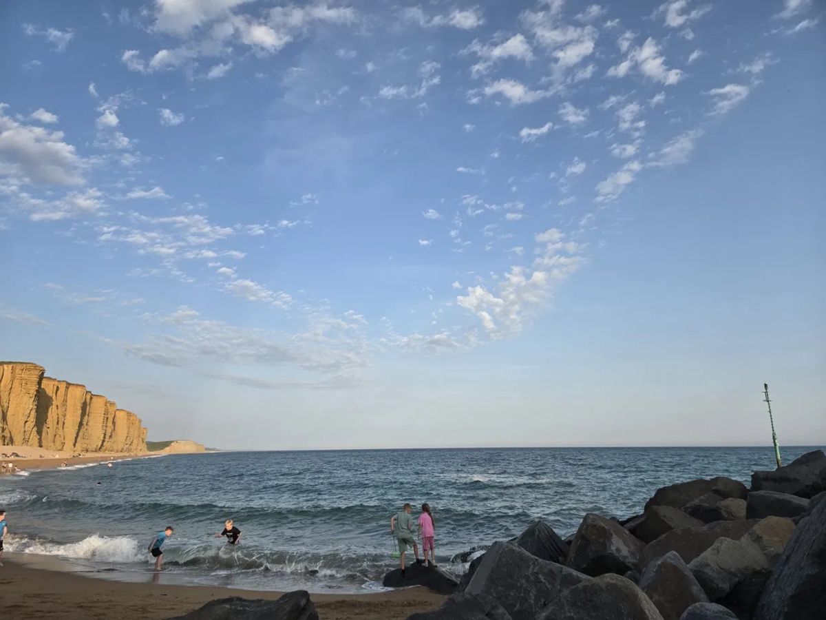A wide sky over the sea, with cliffs in the distance